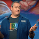 Blizzard President J. Allen Brack shrugging on stage at BlizzConline 2021.